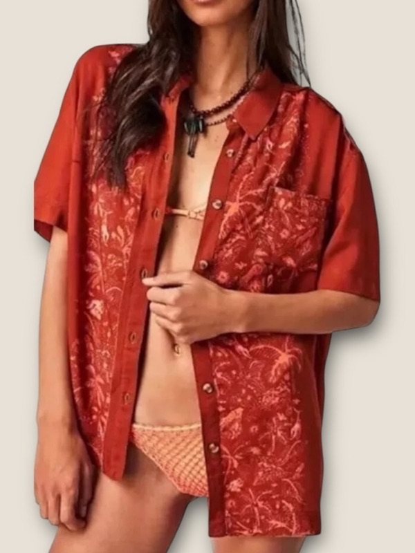 A rust embroidered short-sleeve shirt worn open