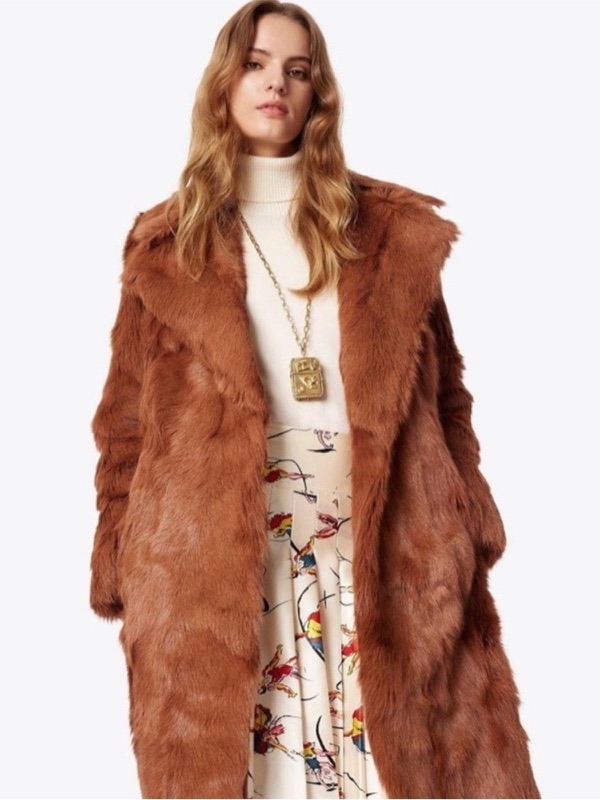 A full-length rust goat fur coat over a floral dress