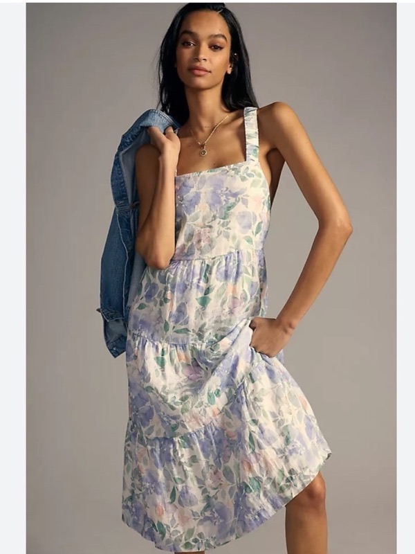 A pastel floral linen dress with a denim jacket over one shoulder